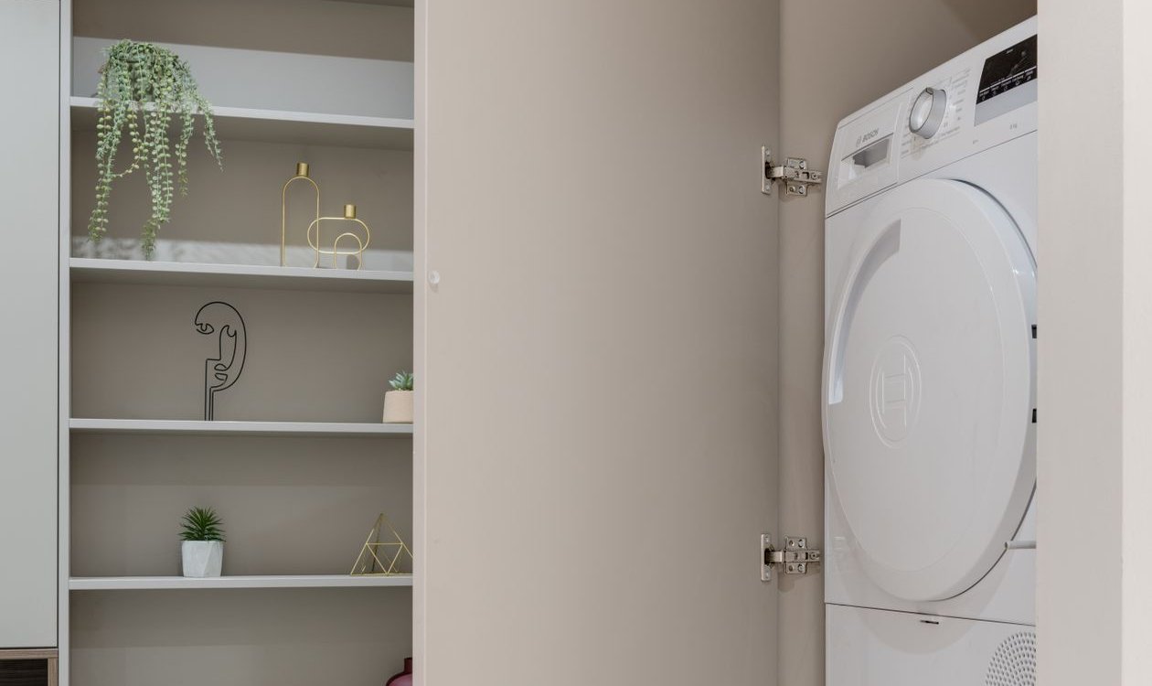 Washer and dryer installed in a hookup closet with hinged doors